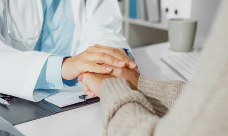 Hands hold a page showing a blue outlined large intestine with a magnifying glass over a section, symbolizing colorectal screening.