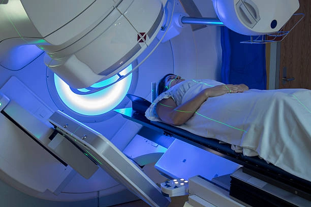 Patient lying on a scanning table inside an MRI machine with a blue-lit bore and laser alignment lines above.